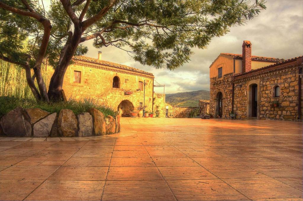 a stone walkway in front of a building with a tree at Le Querce di Cota in Troina