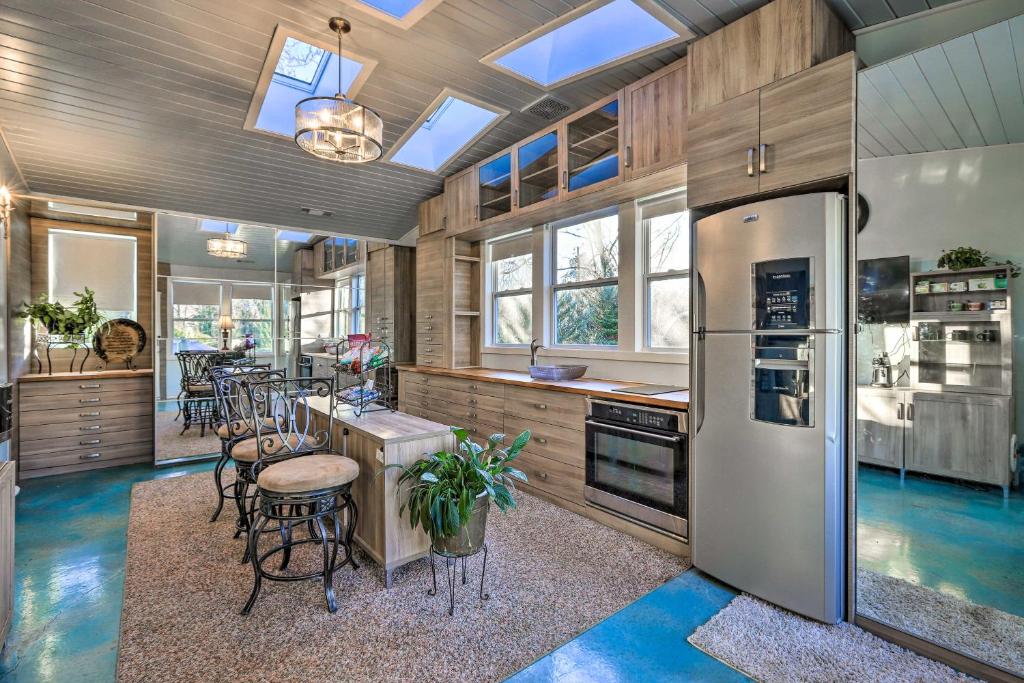 a kitchen with a refrigerator and a bar with stools at Sleek Fayetteville Home Less Than 1 Mi to City Center in Fayetteville