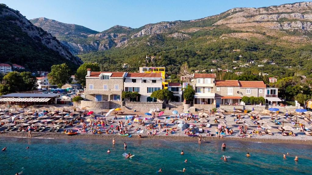 a beach with a bunch of people in the water at Vila Il Pescatore in Petrovac na Moru