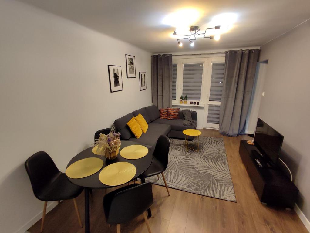 uma sala de estar com um sofá, uma mesa e cadeiras em Apartament Krzemyk em Sandomierz