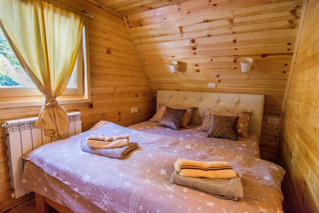 a bedroom with a bed in a wooden cabin at Tisina Tare in Bajina Bašta