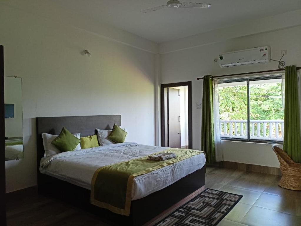 a bedroom with a large bed and a window at Shivaji Inn Kaziranga in Kāziranga