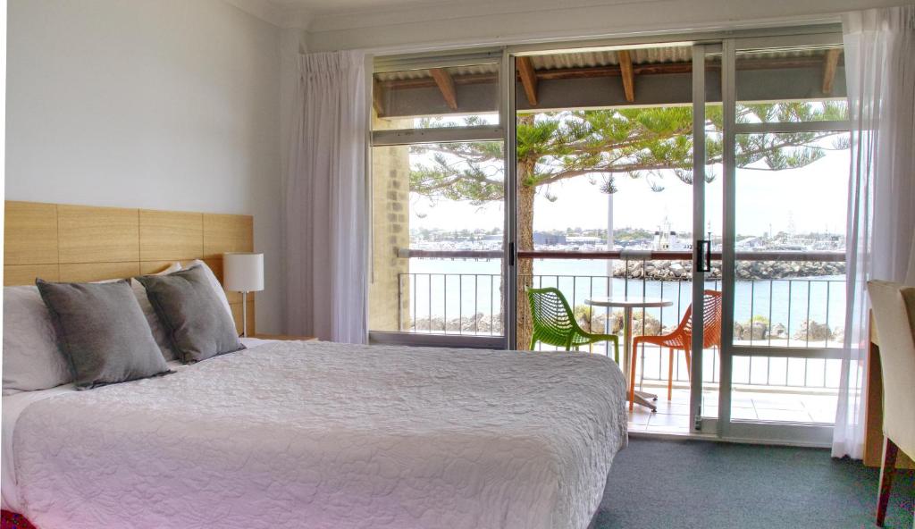 1 dormitorio con 1 cama grande y balcón en Harbourviewocean Views On Fishermans Wharf, en Fremantle