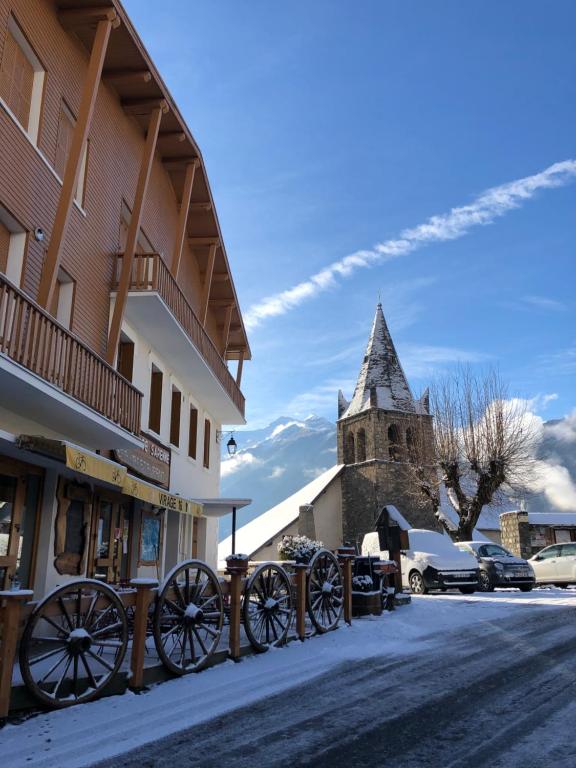 a horse drawn carriage parked next to a building with a church at Appartement rez de jardin montée de l'alpe d'Huez in La Garde