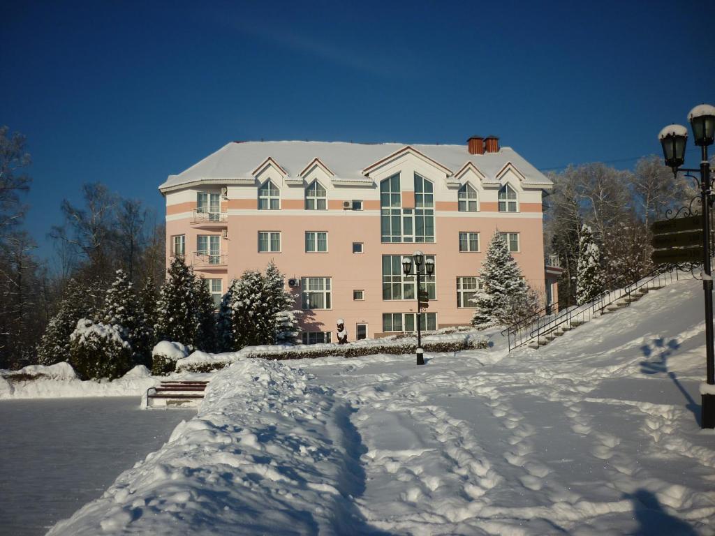 a large pink building with snow in front of it at Buran Resort in Selkovo