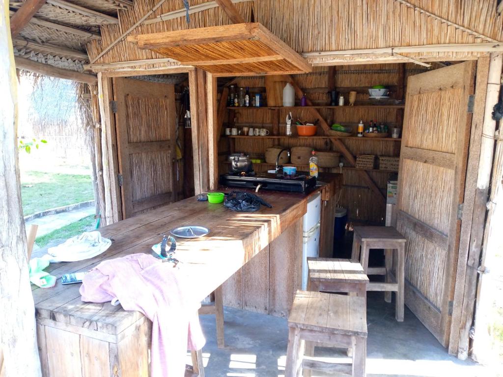 una cucina con tavolo in una casa di legno di Povoado Bitonga a Inhambane