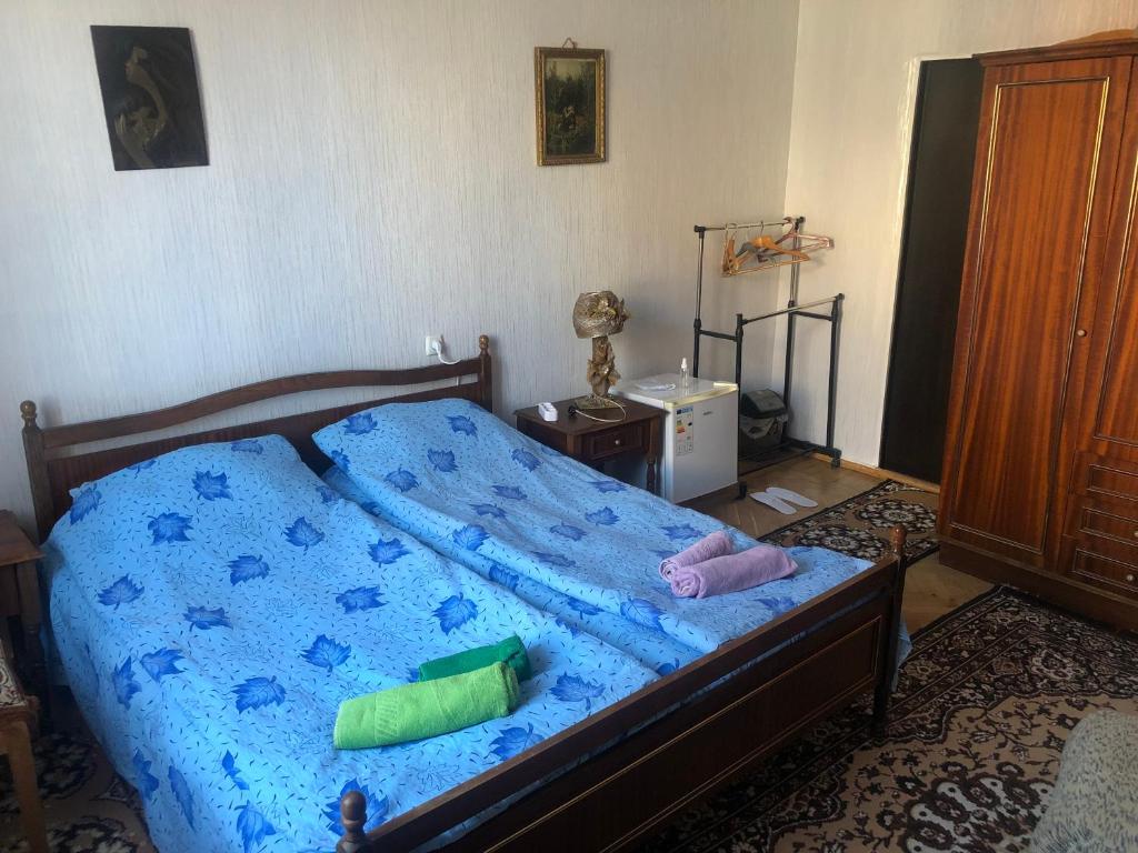 a bedroom with a blue bed with two pillows on it at Rimma Homestay in Tbilisi City