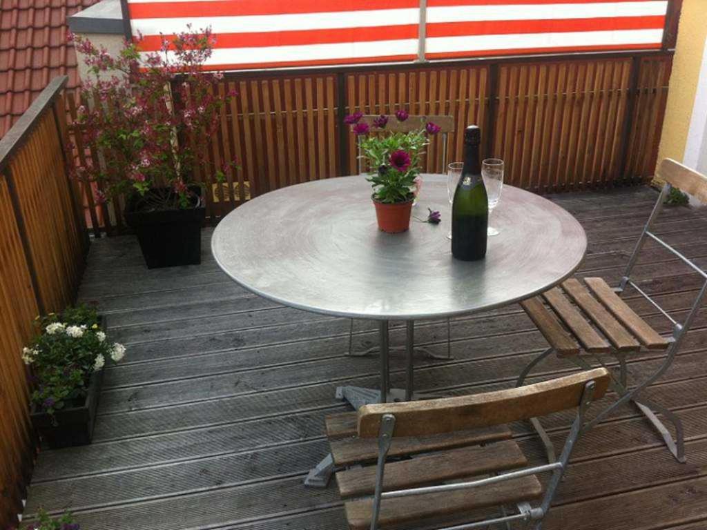 a table with a bottle of wine sitting on a patio at Das Gaestehaus in Offenburg