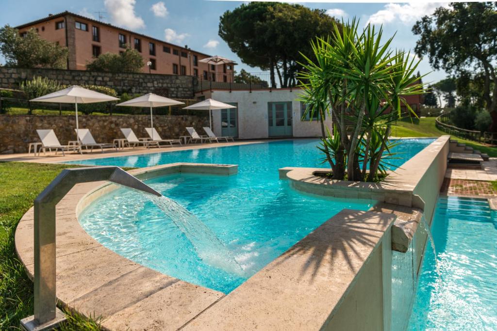 a swimming pool with a palm tree in the middle at Tenuta di Valmora in Massa Marittima