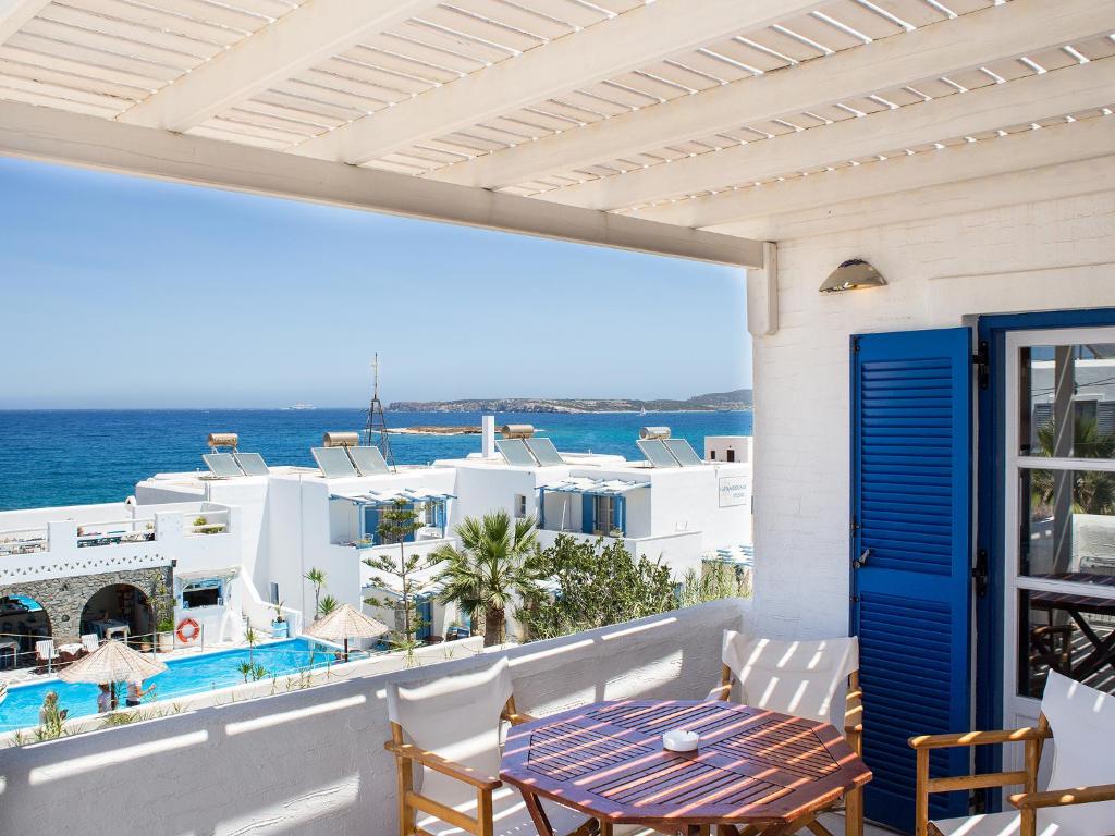balcón con mesa y vistas al océano en Janos Studios and Apartments, en Naousa