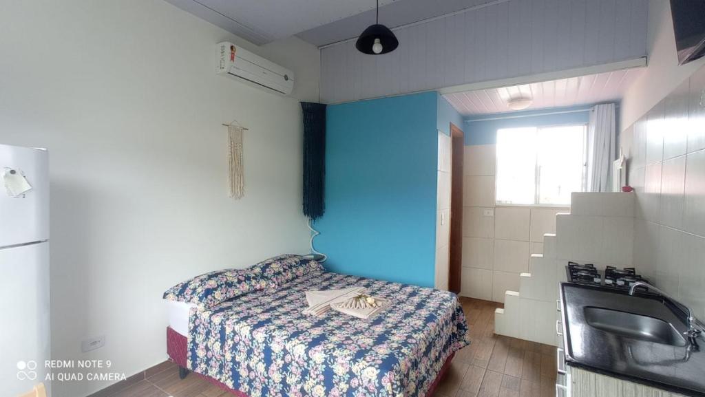 Habitación pequeña con cama y lavamanos en Residencial Natux, en Bombinhas