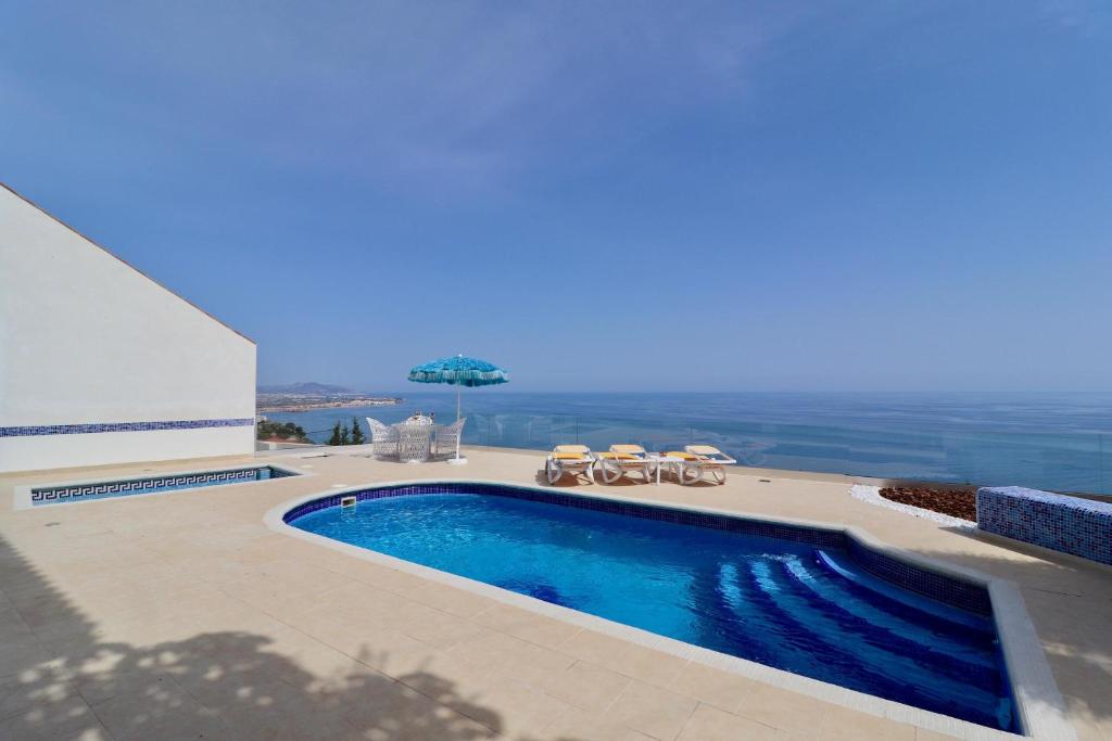 een zwembad met uitzicht op de oceaan bij Villa Tango in Salobreña