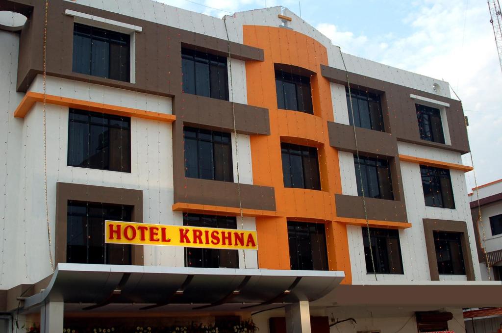 un bâtiment kiryinien avec un panneau kiryinien d'hôtel dans l'établissement Hotel Krishna, à Silvassa