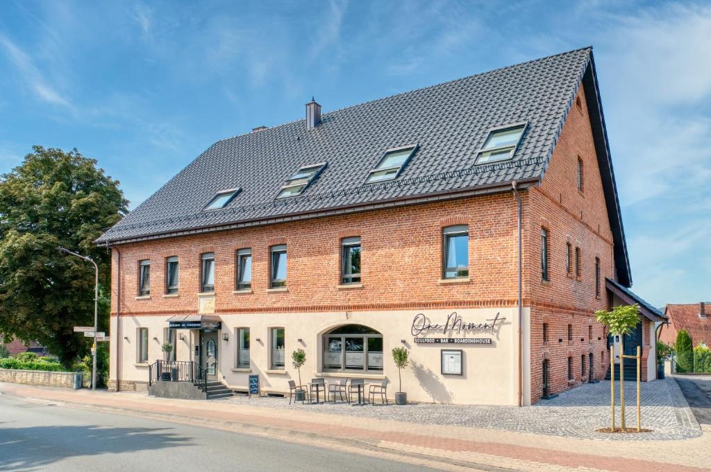 a large red brick building with a black roof at One Moment Boardinghouse - Porta Westfalica in Porta Westfalica