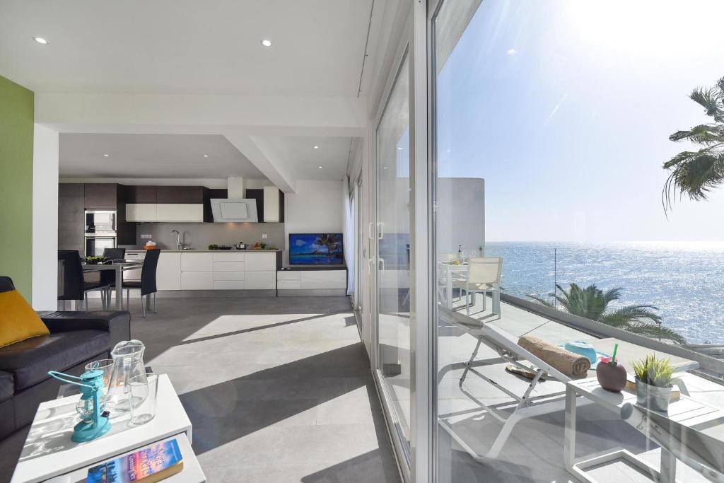 a living room and kitchen with a view of the ocean at Apartment Nueva Suecia CR715 by VillaGranCanaria in San Agustin