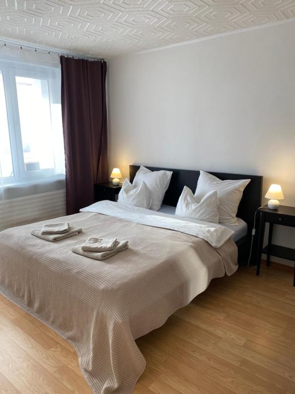 een slaapkamer met een groot bed en 2 handdoeken bij Cozy Center Apartment in Druskininkai in Druskininkai
