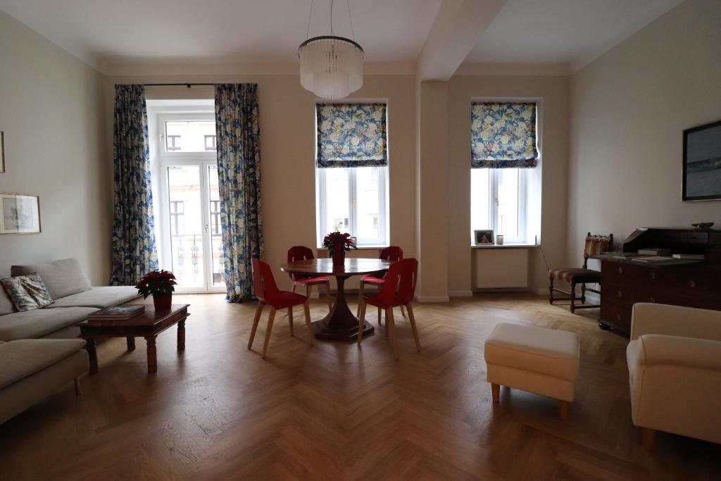 a living room with a table and chairs and windows at Wohnung mit Balkon beim Schloss Belvedere in Vienna