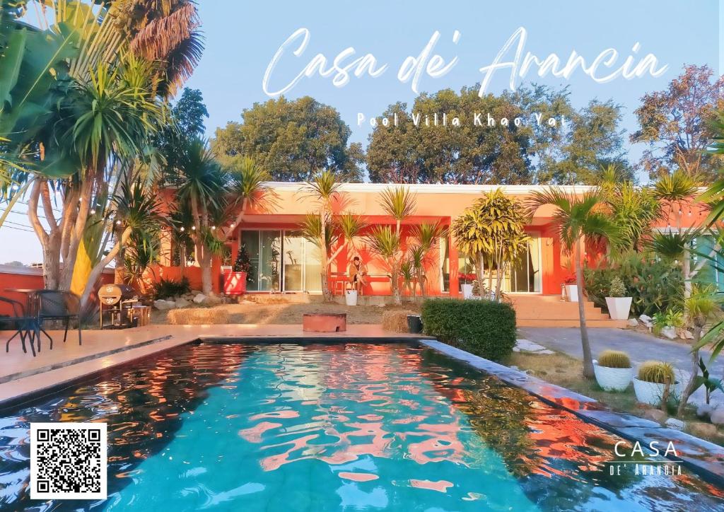 a swimming pool in front of a house with palm trees at Casa De Arancia บ้านพักพูลวิลลา เขาใหญ่ in Ban Khanong Phra Klang (1)