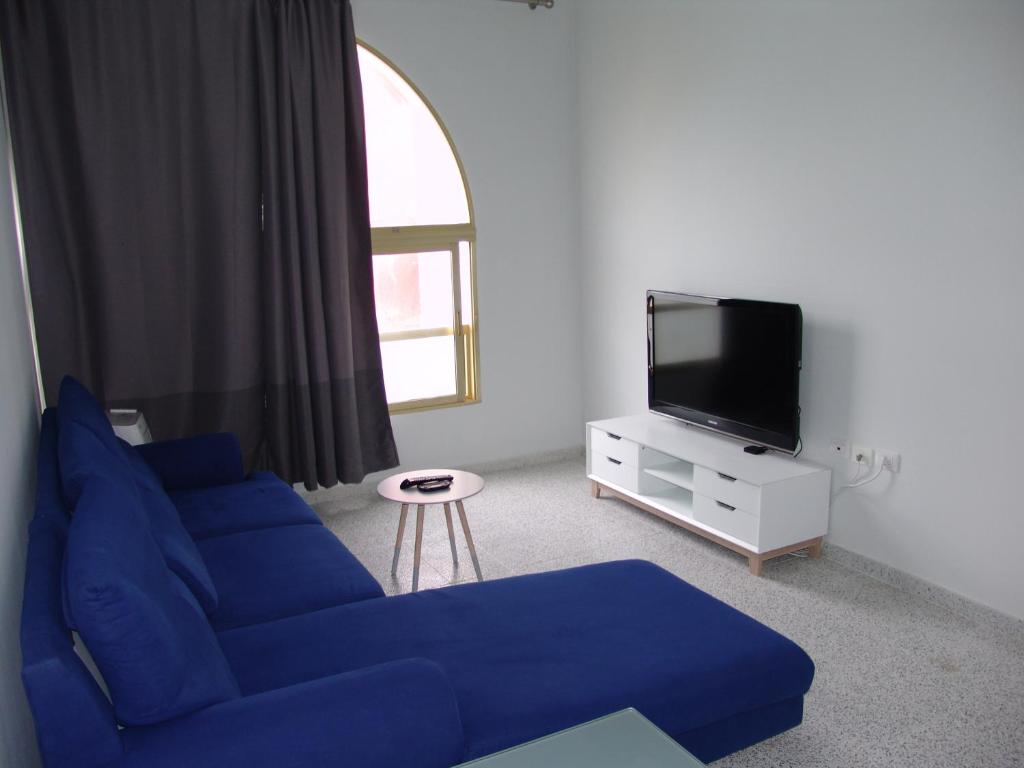 a living room with a blue couch and a tv at ACOGEDOR Apto. 6 pax, TABLERO 1, cerca PLAYA DEL INGLES in El Tablero