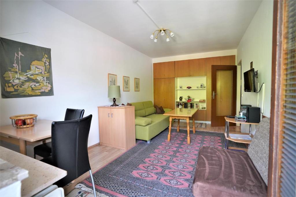 a living room with a green couch and a table at Appartement Petit in Saalbach-Hinterglemm