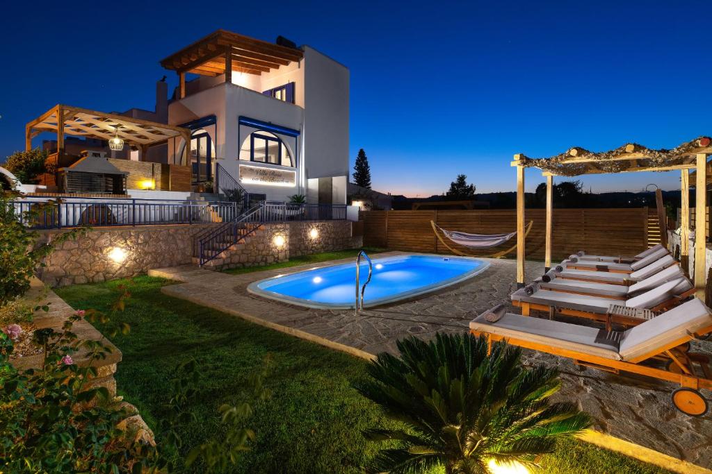 uma villa com piscina em frente a uma casa em Villa Rose on the beach em Afantou