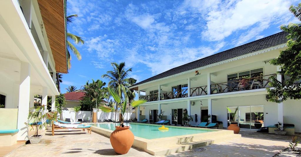- une vue sur l'extérieur d'une villa avec une piscine dans l'établissement Frangi'pwani, à Paje