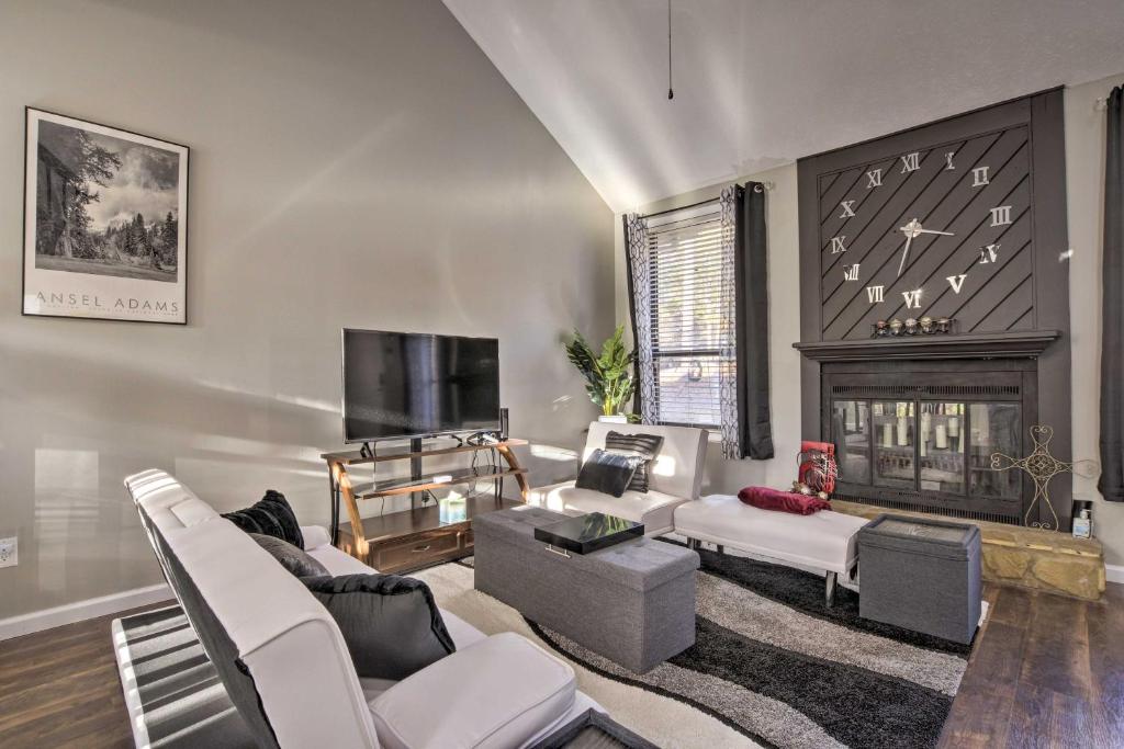 a living room with white furniture and a fireplace at Updated Fayetville Townhome-Away-From-Home with Yard in Fayetteville