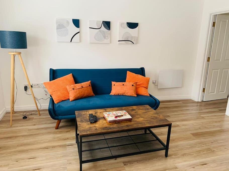 uma sala de estar com um sofá azul e uma mesa em Number Seven em Pembroke Dock