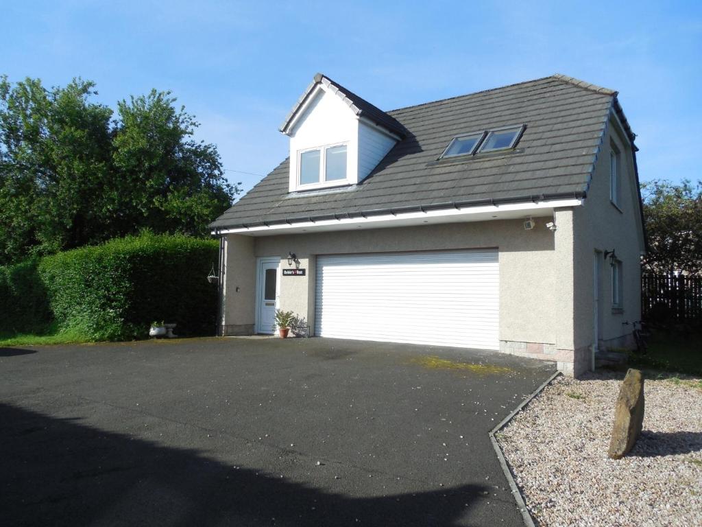 a garage with a white garage door in a driveway at Robin's Rest in Auchterarder