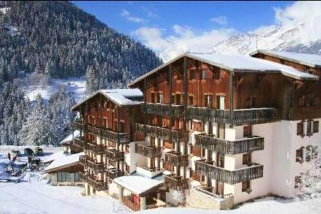 a large building with snow on it in the mountains at Studio avec balcon a Modane in Modane