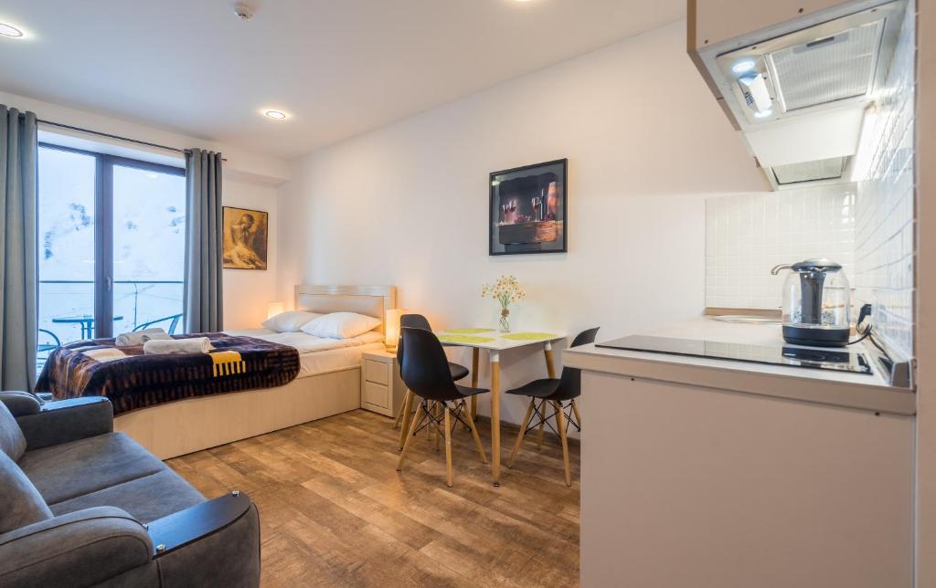 a hotel room with a bed and a kitchen with a table at GVC 240-2 New Gudauri in Gudauri