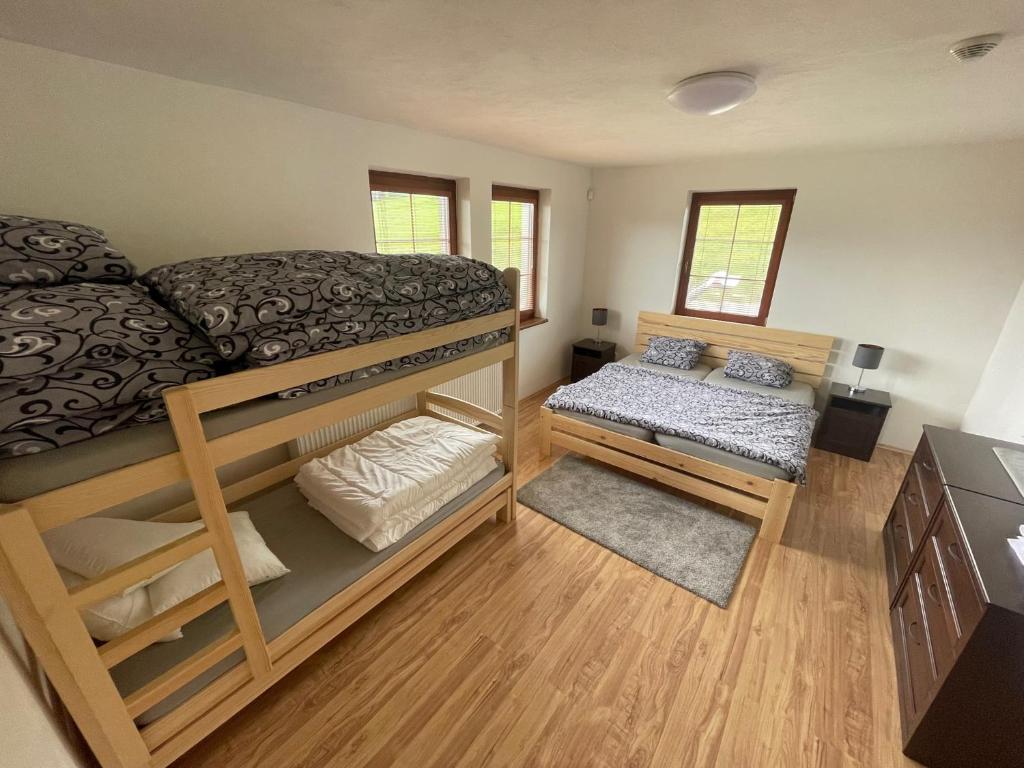 a bedroom with two bunk beds and a small bed at Apartmany215 in Strážné