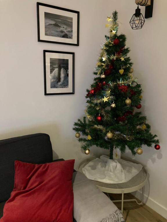 een kerstboom in een woonkamer met een bank bij kercady 1 in Audierne