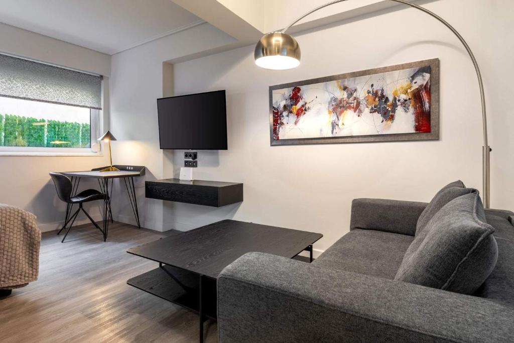 a living room with a couch and a tv at Brand-New , Delux apt in Central Athens! in Athens