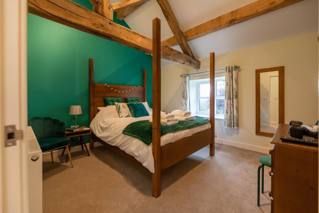 a bedroom with a bed and a green wall at Dyffryn Cottage - King bed, self-catering cottage with Hot Tub in Denbigh