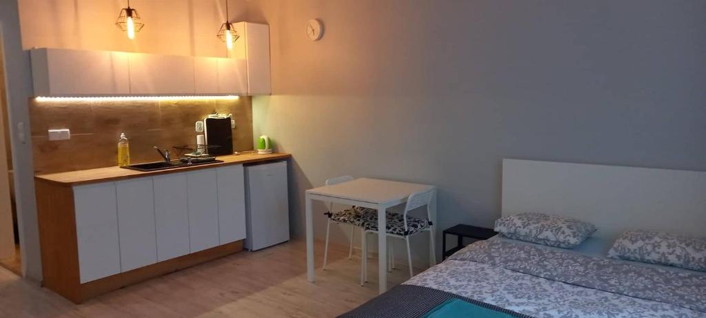 mały pokój z łóżkiem i kuchnią ze zlewem w obiekcie Apartament Be Happy Nr 2 w mieście Gdynia