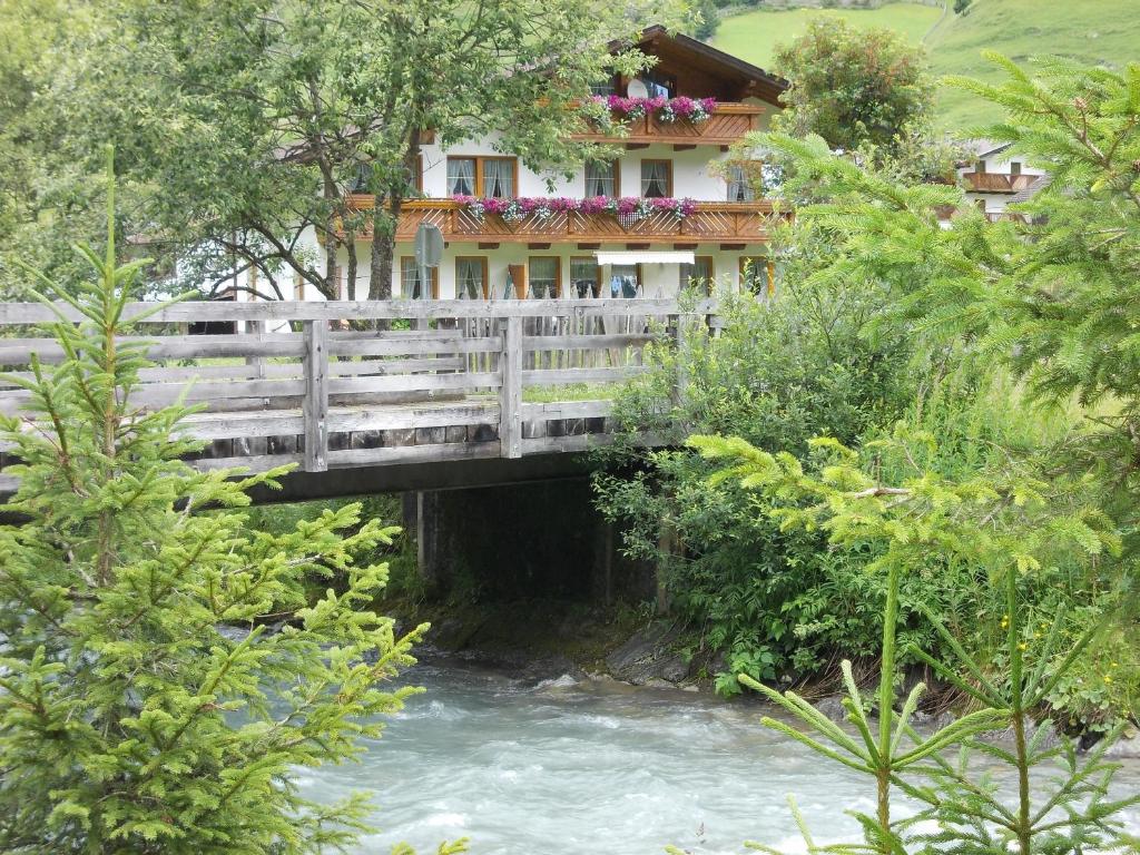 a bridge over a river with a house on it at Haus Schoderböck in Sankt Leonhard im Pitztal