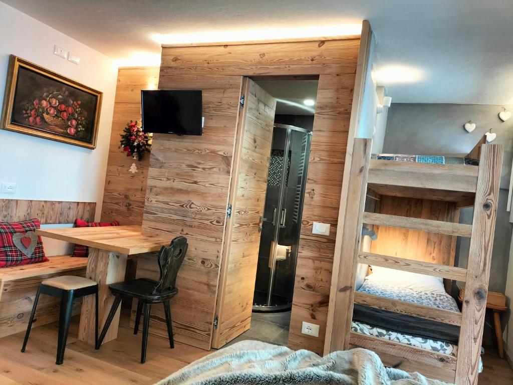 a room with a table and a bunk bed at Appartamento Campiglio 2 in Madonna di Campiglio