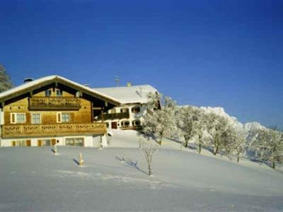 a ski lodge with snow covered trees and a building at Lehnhäusl Aschauer in Berchtesgaden