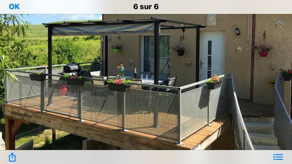 une terrasse avec un parasol et des plantes en pot dans l'établissement Maison de 3 chambres avec jardin clos et wifi a Chavot Courcourt, à Chavot-Courcourt