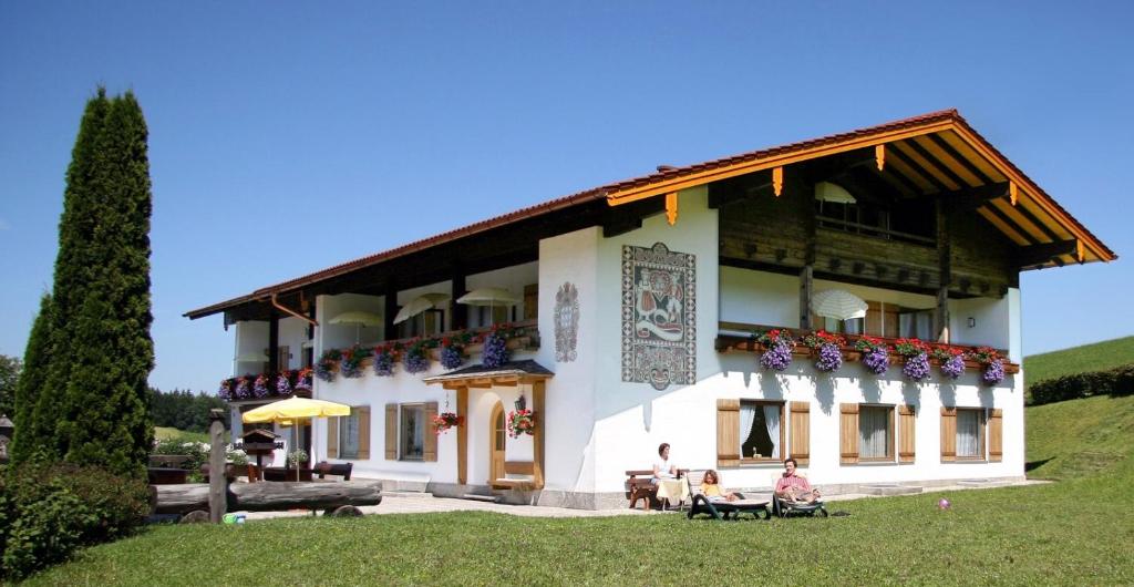 a white building with people sitting outside of it at Gästehaus Meisl in Berchtesgaden