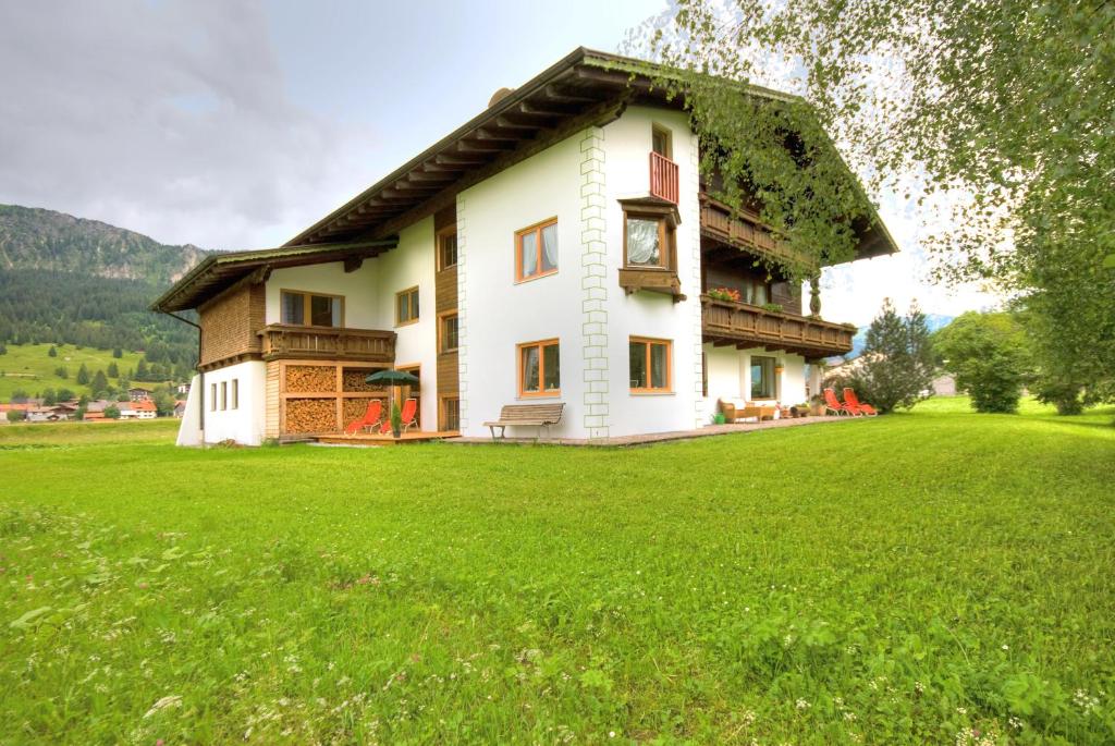 ein Haus mit grünem Rasen davor in der Unterkunft Apartments Tannheim in Tannheim