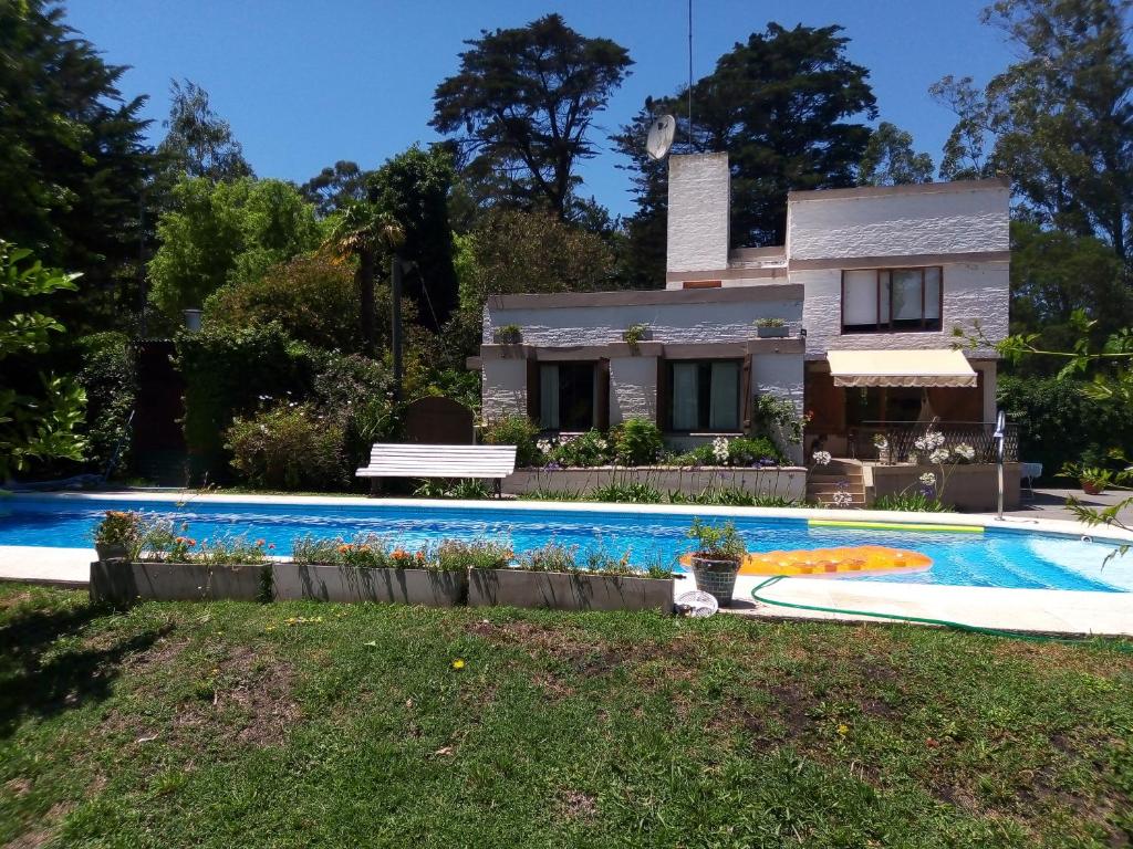 a house with a swimming pool in front of a house at Casa Cuatro Robles in Mar del Plata