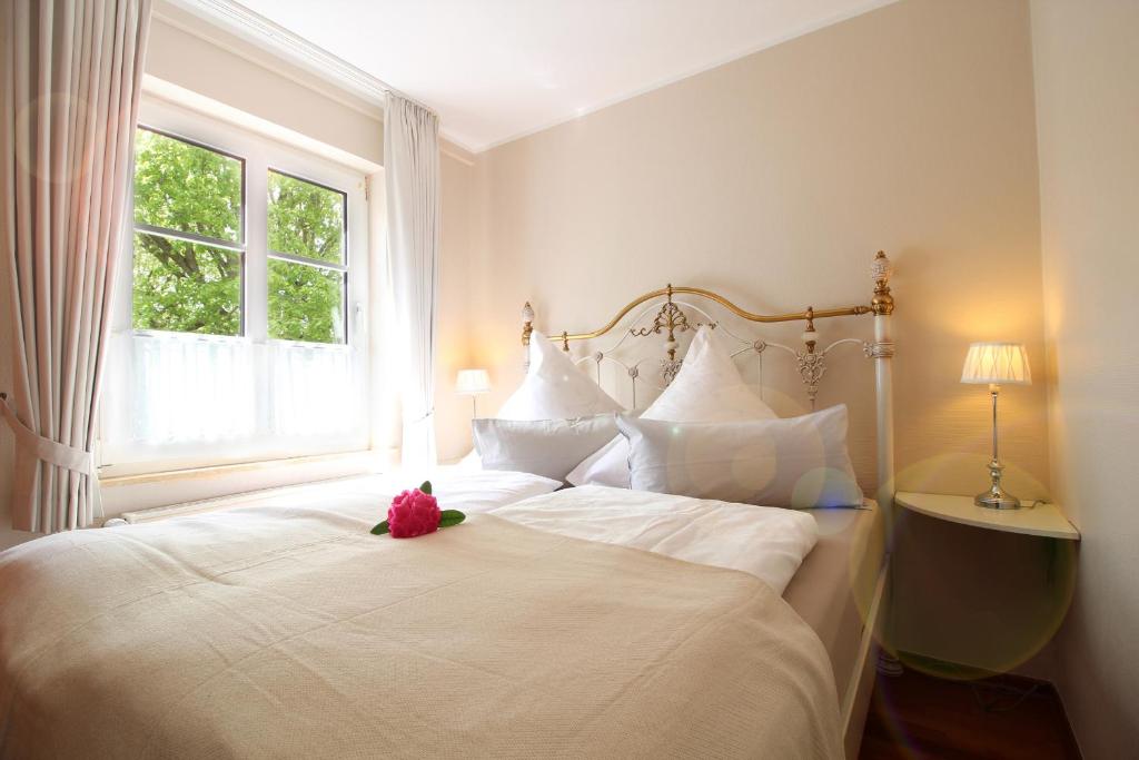 Un dormitorio con una cama blanca con un osito de peluche. en Haus Gerd Janssen Wohnung 1, en Spiekeroog