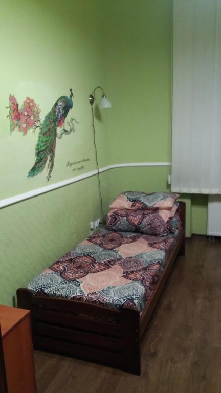 a bedroom with a bed with a bird on the wall at Lviv City Hostel in Lviv