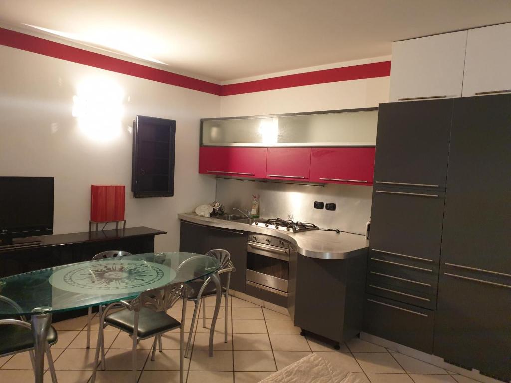 a kitchen with red cabinets and a table in it at Apartment Airport in Bergamo