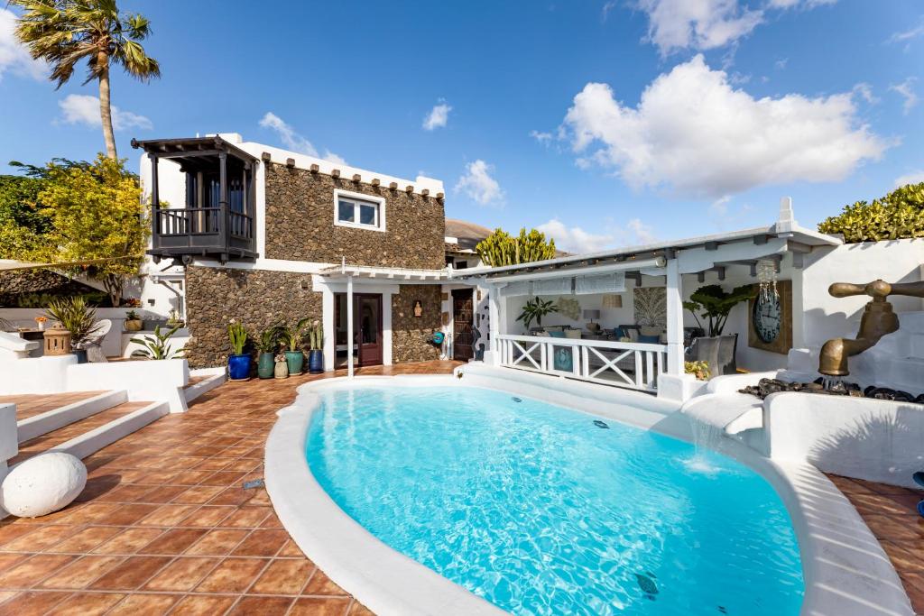 a swimming pool in the backyard of a house at Deluxe designer historic villa Via Lactea, Panoramic sea views, Own private heated pool and subtropical garden in La Asomada