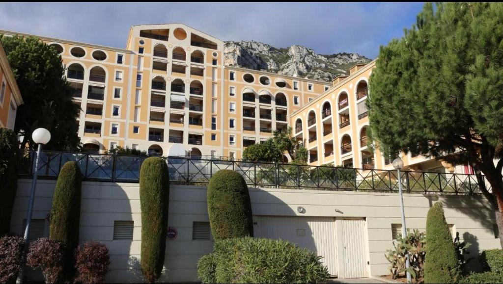 a large building with a mountain in the background at Azzurra in Beausoleil