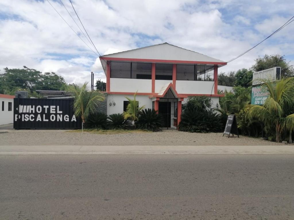 un edificio con una señal delante de él en Piscalonga Hotel, en San Lorenzo de Guayubín