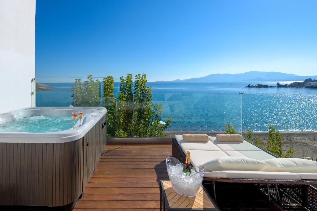 a hot tub on a deck with a view of the water at Villa Haraki Paradise in Haraki